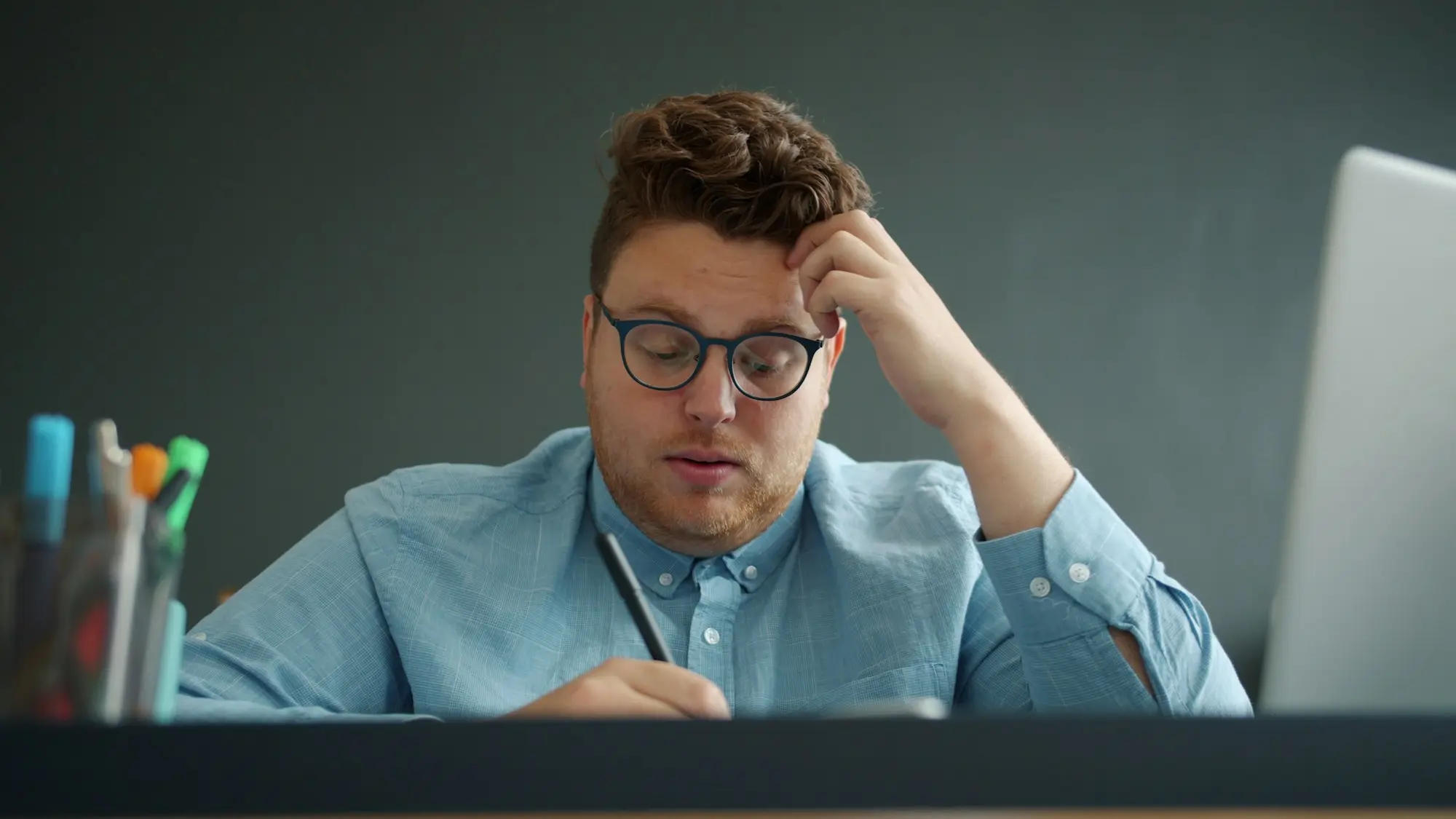 Director reading a letter at his desk with a worried look