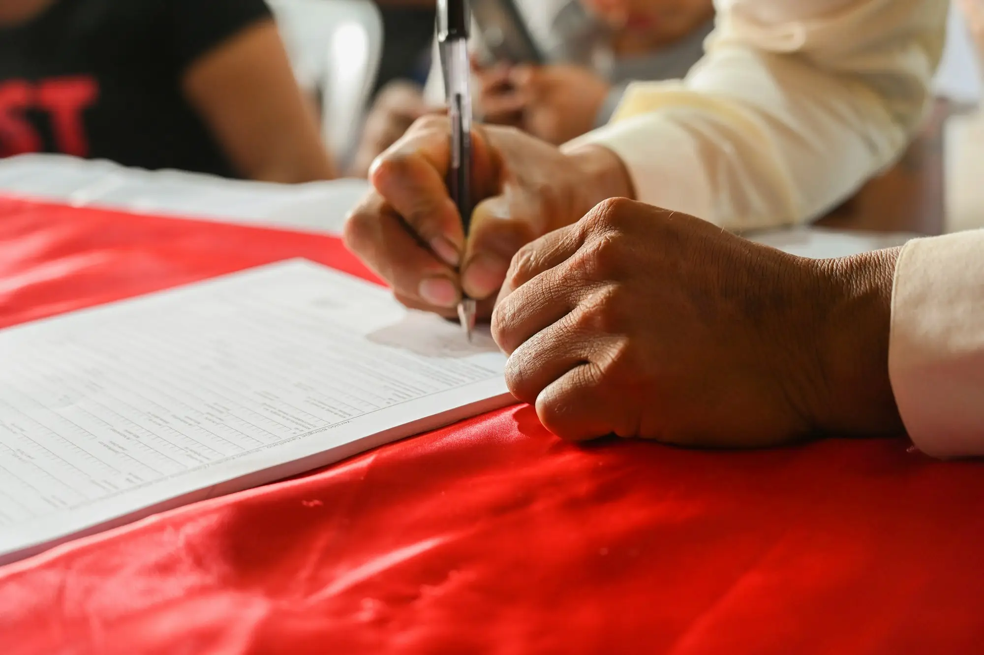Hands signing loan documents on a desk