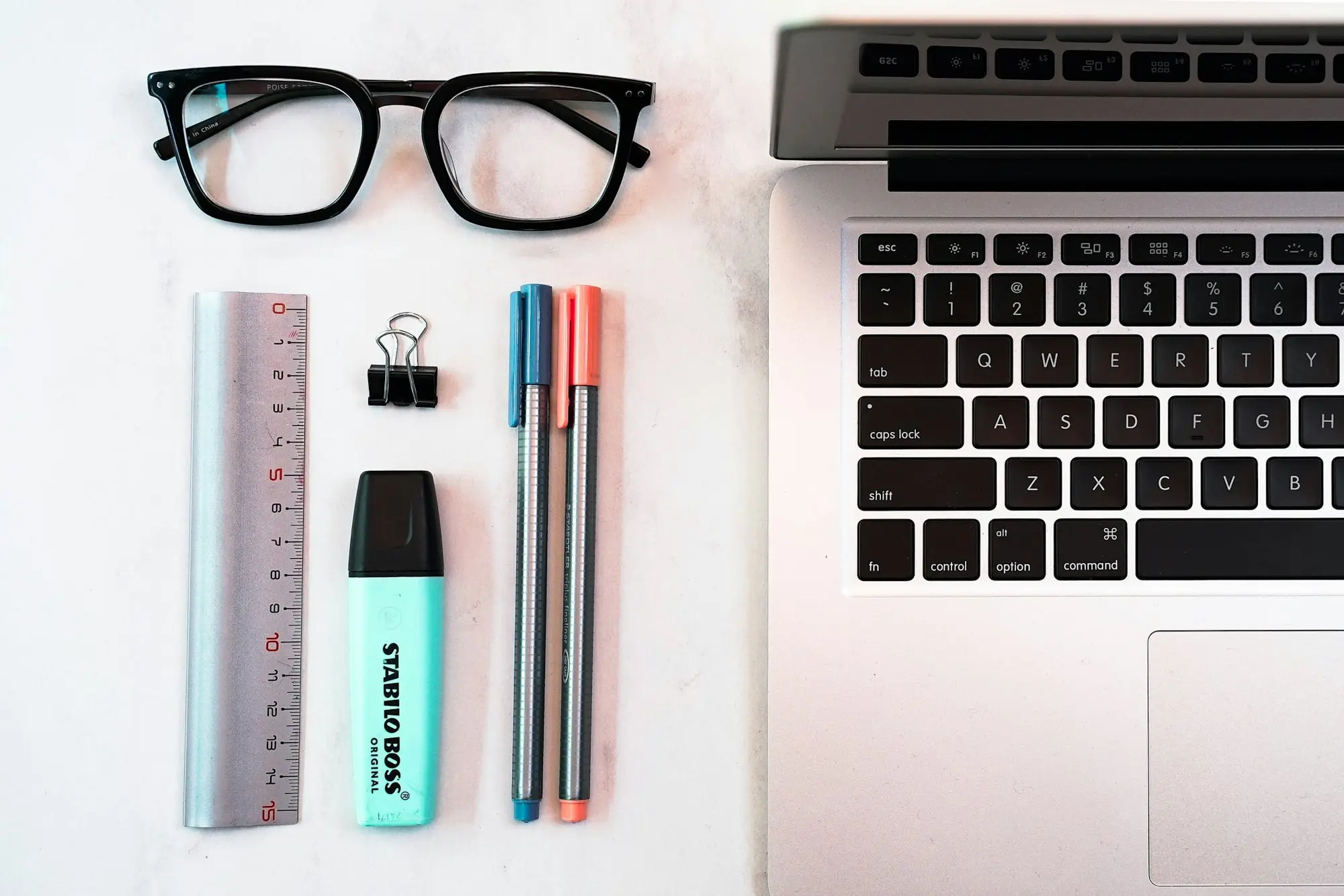 Glasses, ruler, pens and laptop on a desk for a title search